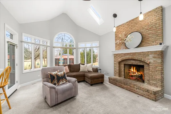 a living room with furniture a fireplace and a large window