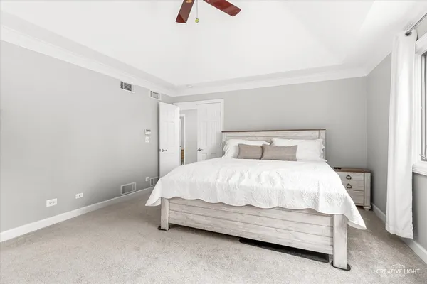 a bedroom with a bed and a ceiling fan
