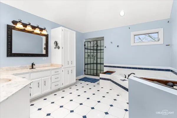 a spacious bathroom with a sink a mirror and shower