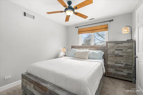 a bedroom with a bed and a ceiling fan