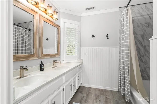 a bathroom with double vanity sink and a mirror