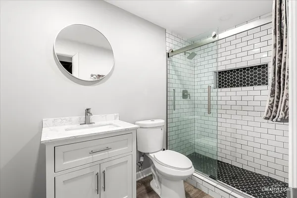 a bathroom with a sink a toilet and a mirror