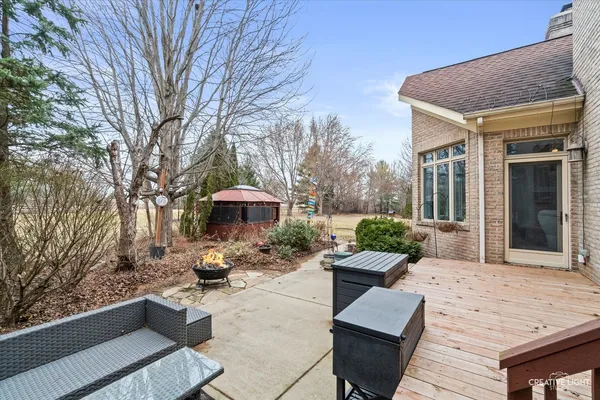 a view of a patio with couches table and chairs with wooden floor and fence
