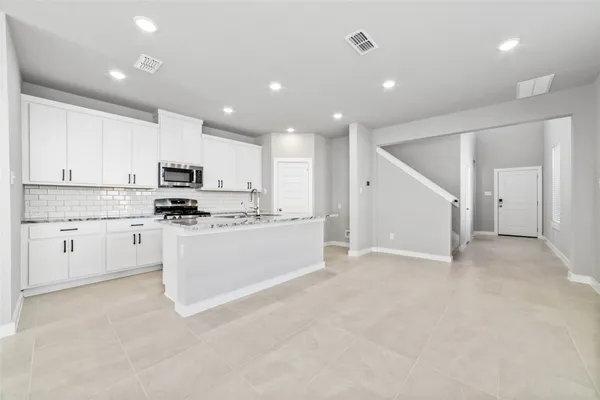 a large white kitchen with white cabinets