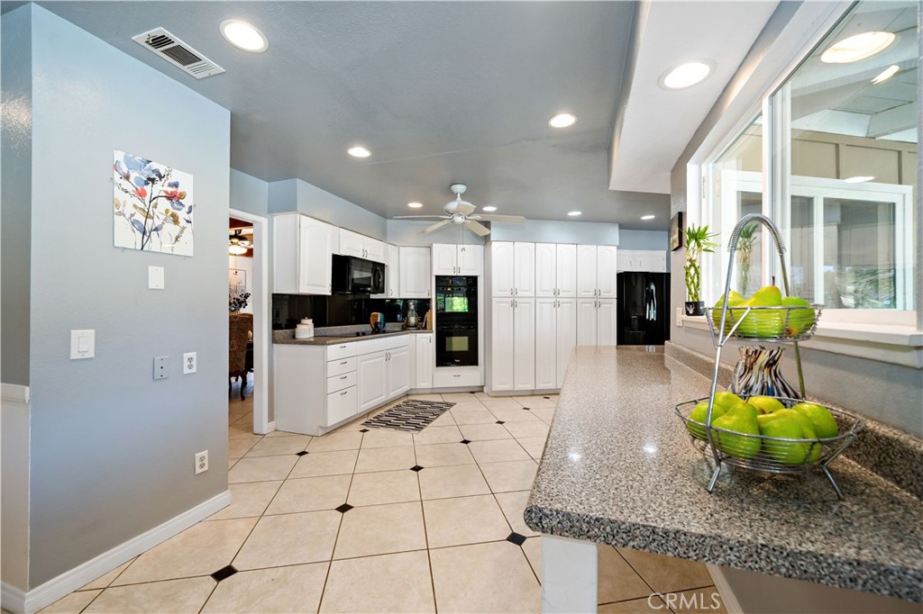 39980 Vía Fernando Temecula, CA 92592 - Photo 29 of 73 a kitchen with stainless steel appliances kitchen island granite countertop a refrigerator and a sink