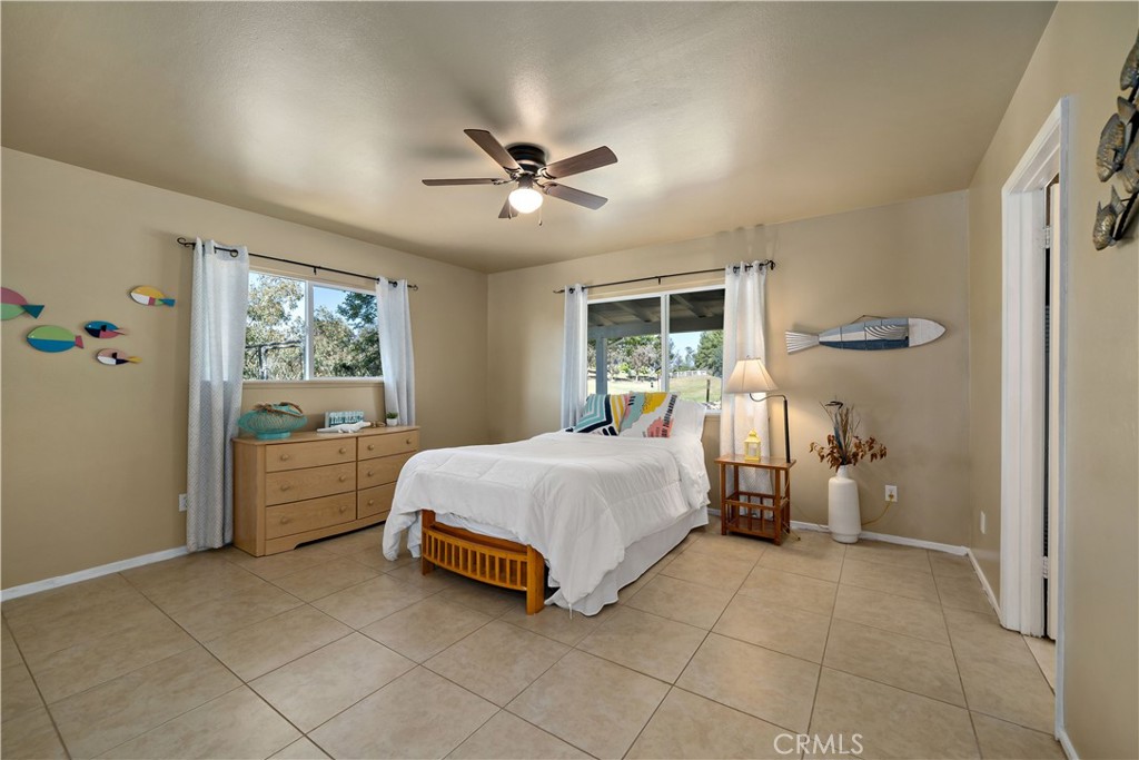 39980 Vía Fernando Temecula, CA 92592 - Photo 34 of 73 a spacious bedroom with a bed and a chandelier