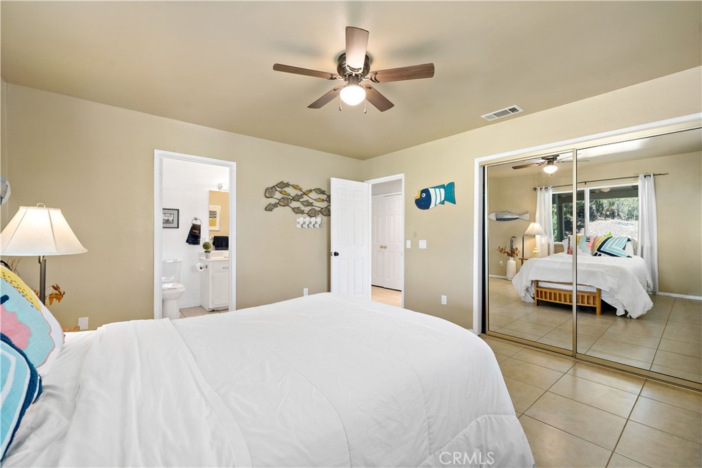 39980 Vía Fernando Temecula, CA 92592 - Photo 35 of 73 a bedroom with a large bed and a chandelier