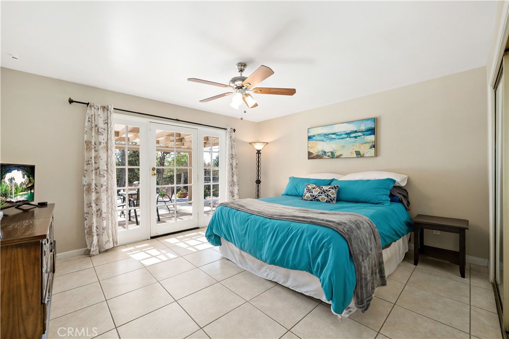 39980 Vía Fernando Temecula, CA 92592 - Photo 37 of 73 a bedroom with a large bed and a chandelier fan
