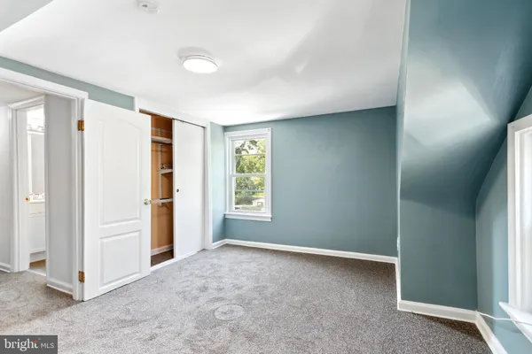 an empty room with windows and closet