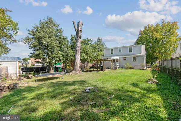 a view of a house with backyard and a tree