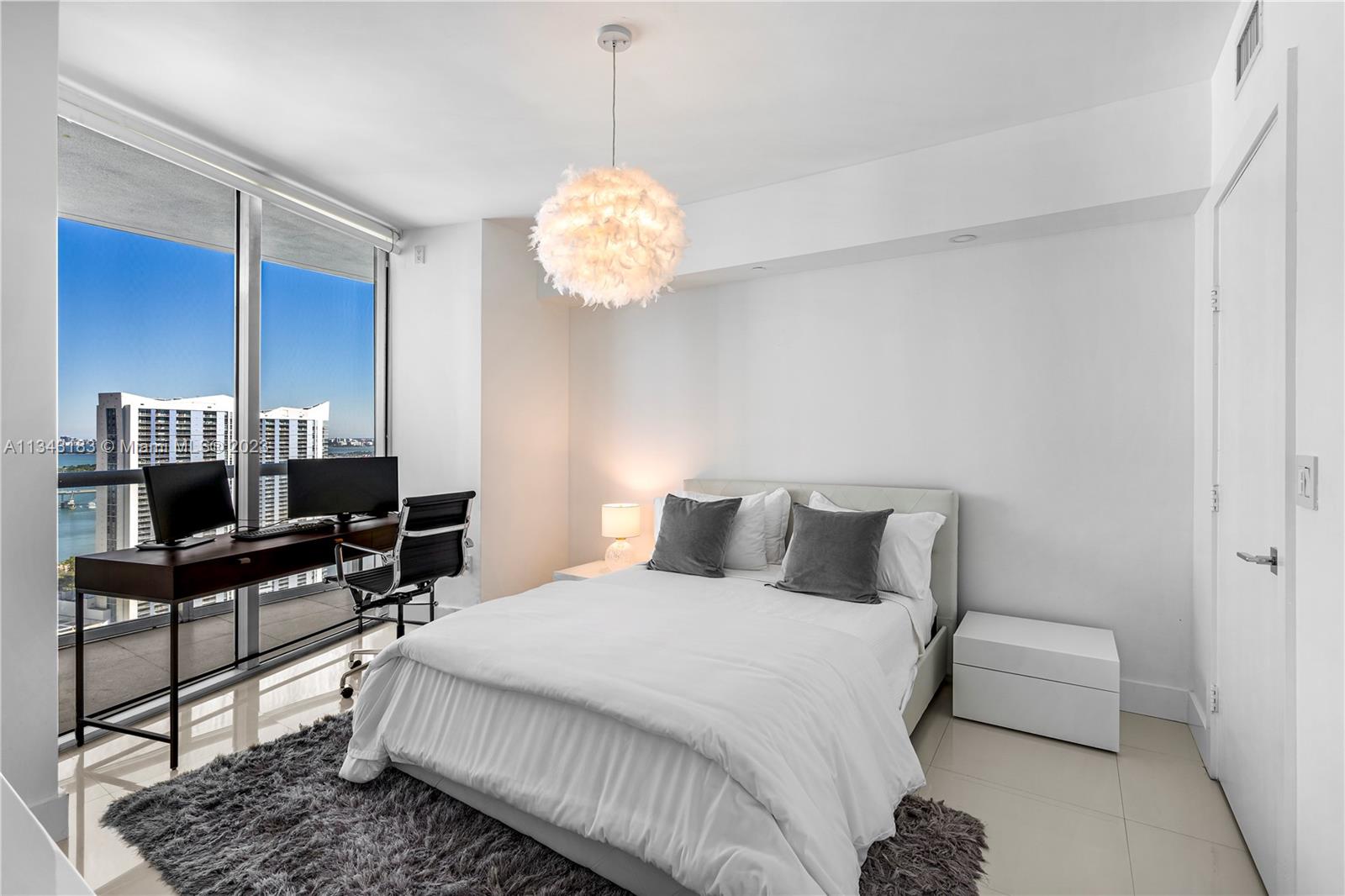 495 Brickell Avenue, Unit 3804 Miami, FL 33131 - Photo 12 of 23 a bedroom with a bed and a chandelier