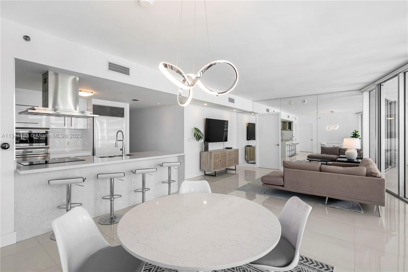 495 Brickell Avenue, Unit 3804 Miami, FL 33131 - Photo 5 of 23 a large kitchen with kitchen island a white cabinets and stainless steel appliances