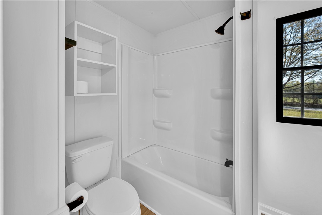220 Bill Kay Road Belton, SC 29627 - Photo 11 of 30 This clean and functional bathroom features a shower and built-in shelving, offering convenience and organization.