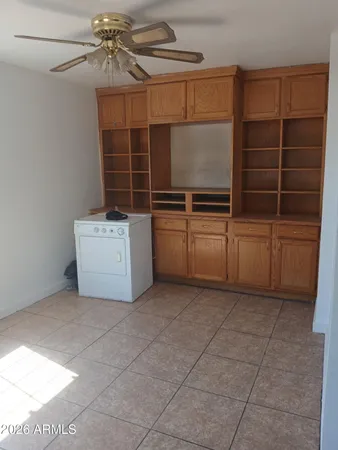 a view of an empty room with cabinet and a window