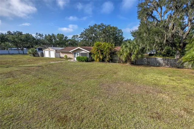 a front view of a house with a yard and trees