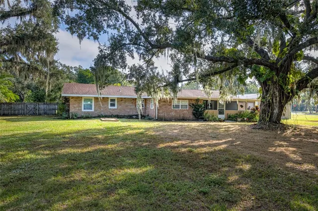 a front view of a house with a yard and trees