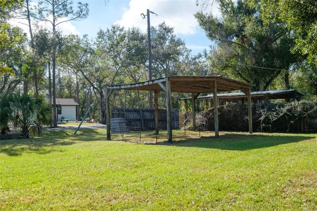 a view of a swimming pool with a patio and a yard