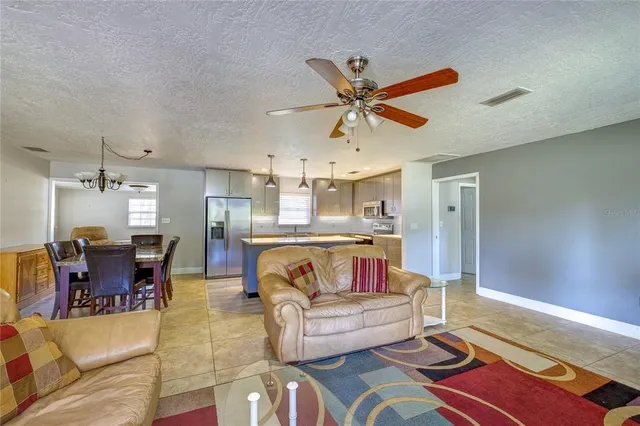 a living room with furniture and a dining table with kitchen view