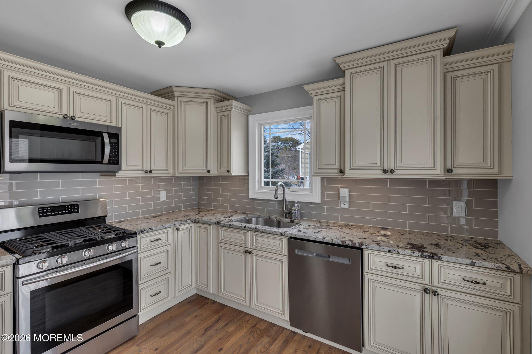 27 Branch Road Oakhurst, NJ 07755 - Photo 17 of 44 a kitchen with granite countertop a sink stainless steel appliances and white cabinets