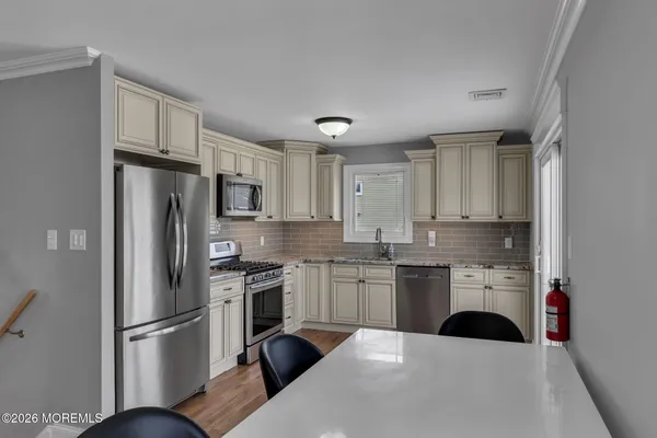 a kitchen with stainless steel appliances a refrigerator sink and cabinets