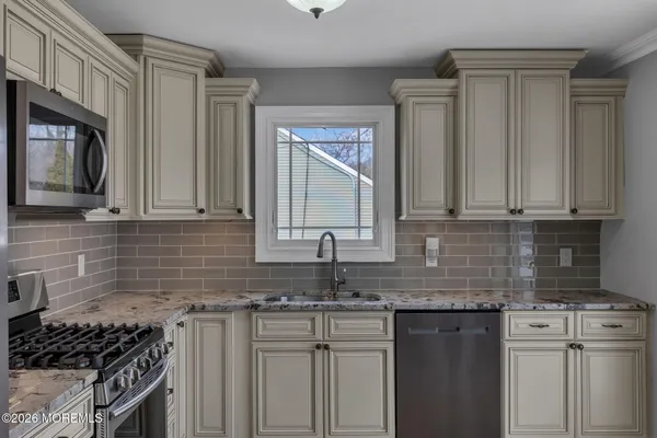 a kitchen with stainless steel appliances granite countertop a sink stove and cabinets