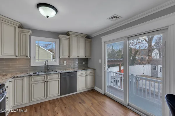 a kitchen with a sink window and cabinets