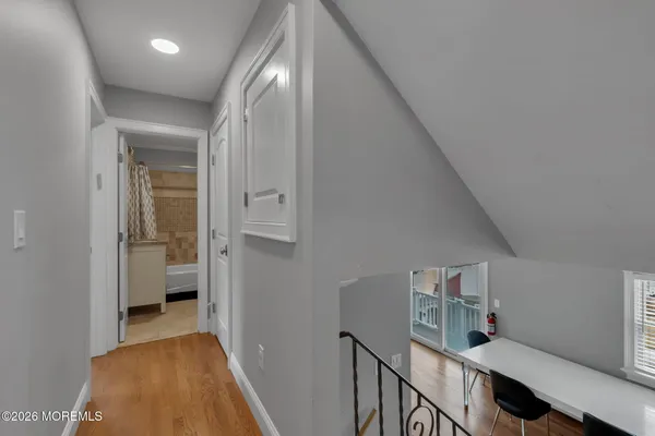 a view of a hallway with bathroom and wooden floor