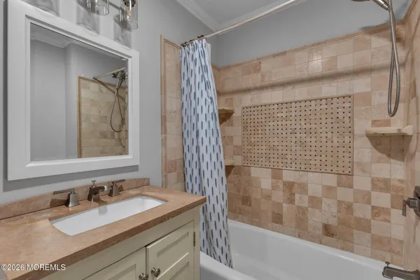 a bathroom with a granite countertop sink a mirror and shower