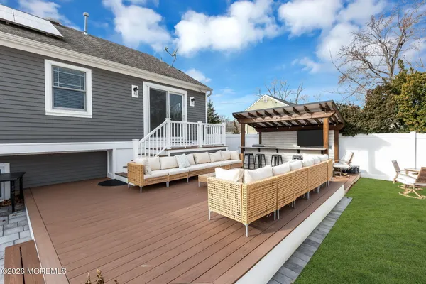 a view of a house with wooden deck and furniture