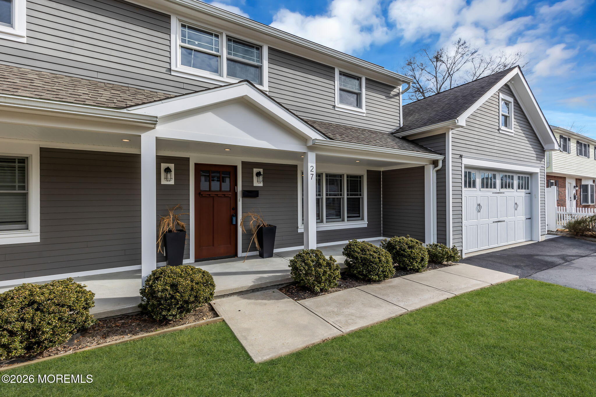 27 Branch Road Oakhurst, NJ 07755 - Photo 4 of 44 a front view of a house with a garden and plants