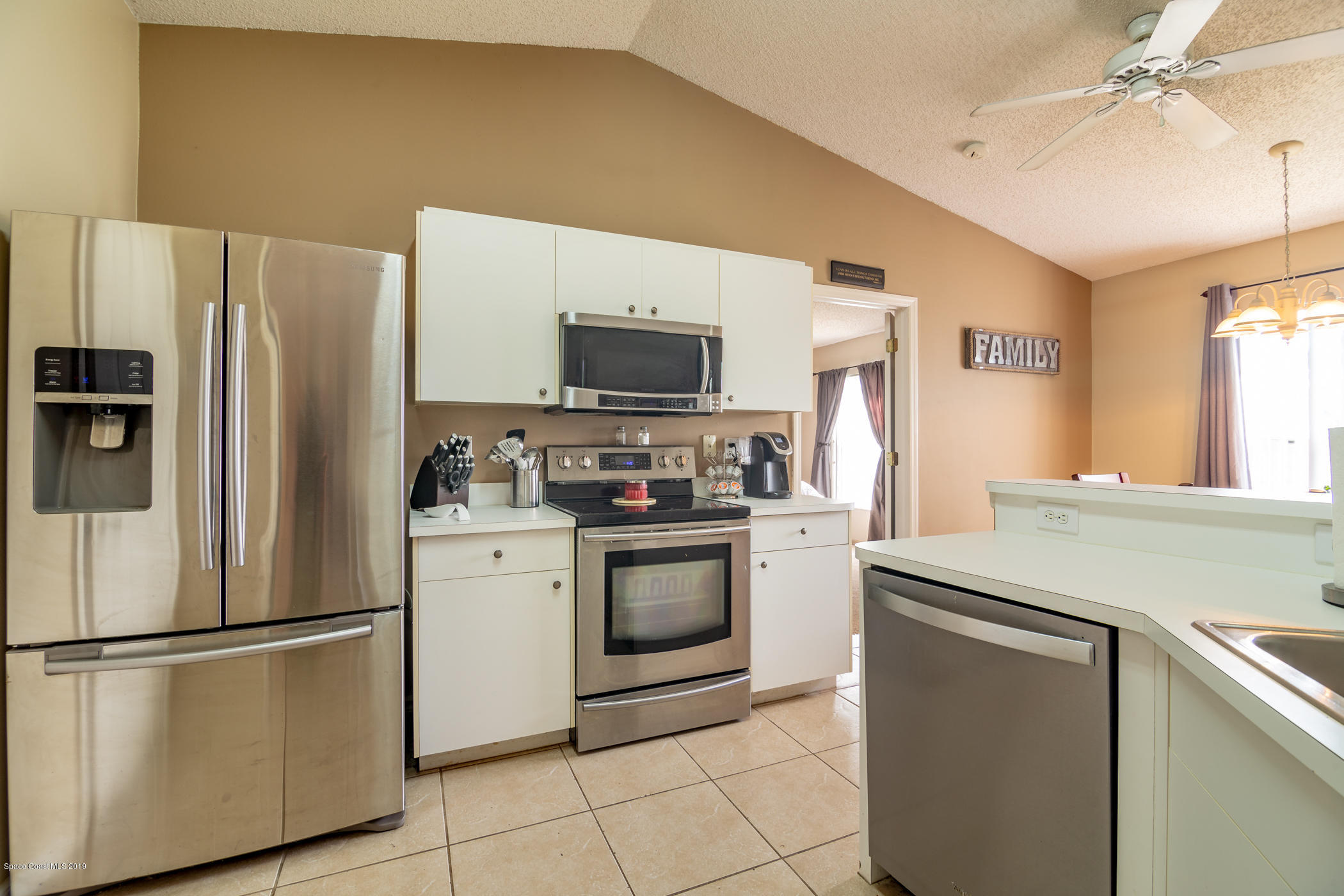 5585 Flint Road Cocoa, FL 32927 - Photo 5 of 14 a kitchen with stainless steel appliances a refrigerator sink and microwave