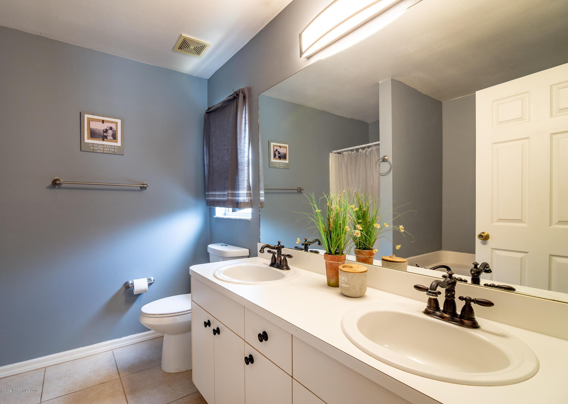 5585 Flint Road Cocoa, FL 32927 - Photo 7 of 14 a bathroom with a double vanity sink and a mirror