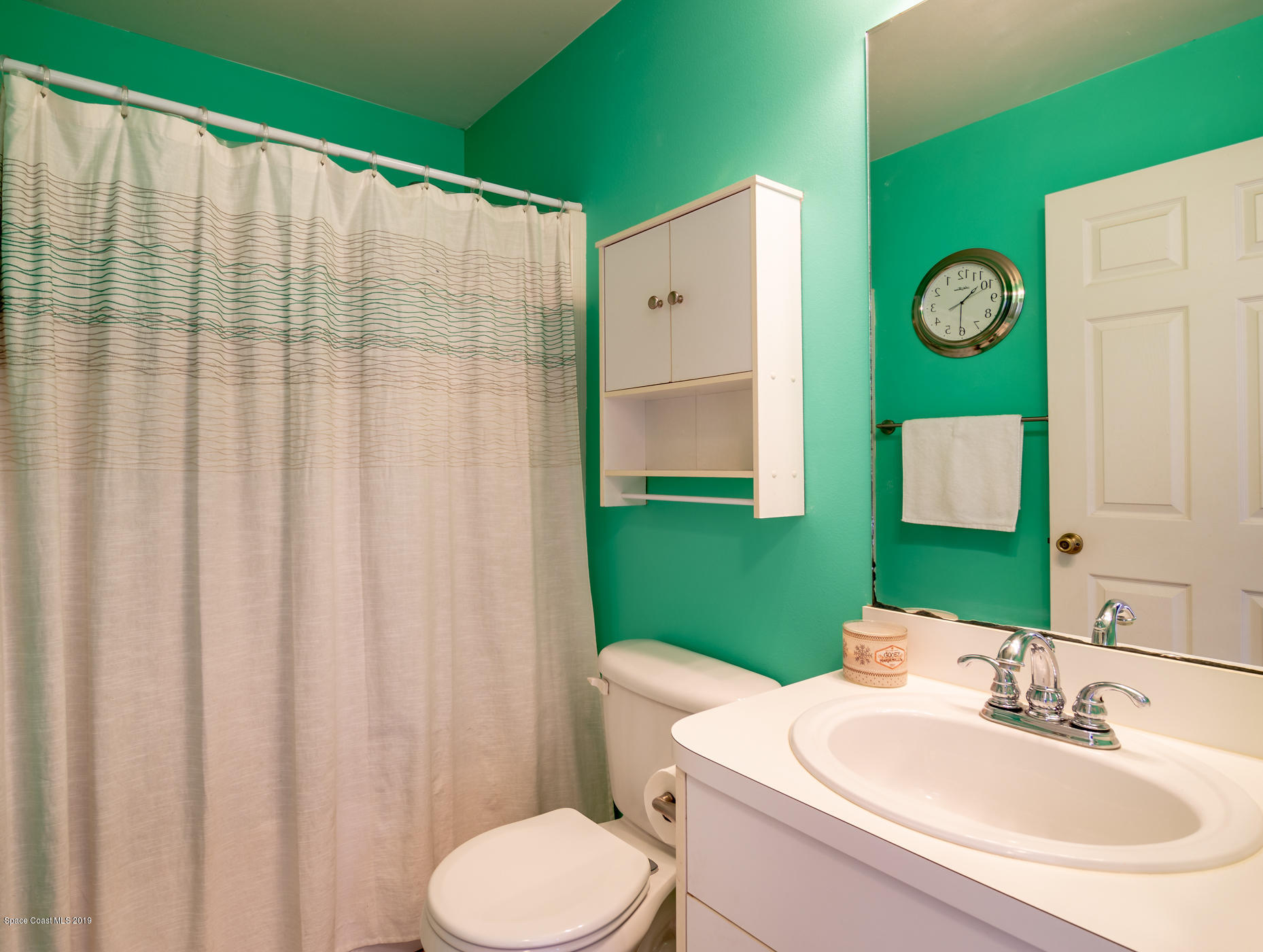 5585 Flint Road Cocoa, FL 32927 - Photo 10 of 14 a bathroom with a sink a toilet and a mirror
