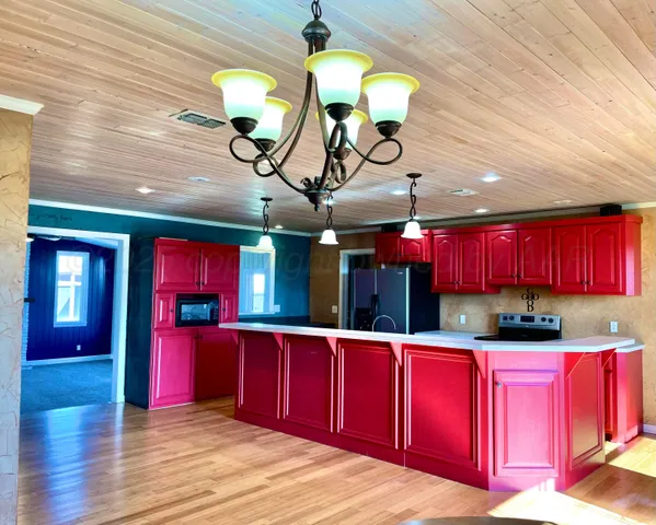 a kitchen with stainless steel appliances granite countertop a stove window and wooden cabinets