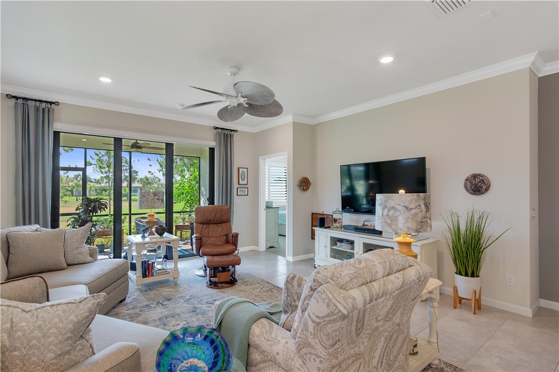 5122 Unity Square Vero Beach, FL 32967 - Photo 11 of 33 a living room with furniture a large window a flat screen tv and a large window