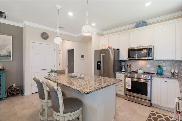 a kitchen with center island table and chairs