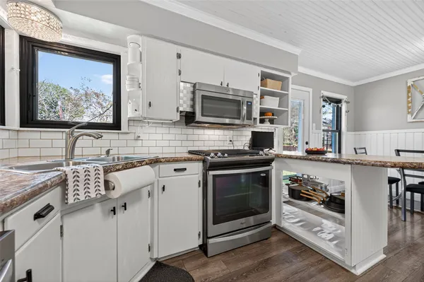 a kitchen with stainless steel appliances granite countertop a stove microwave and sink