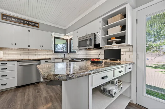 a kitchen with stainless steel appliances granite countertop a stove a sink and a microwave