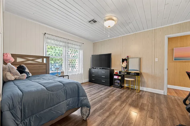 a bedroom with a bed and a flat screen tv