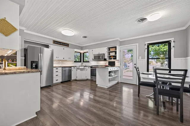 a kitchen with a table chairs refrigerator and cabinets