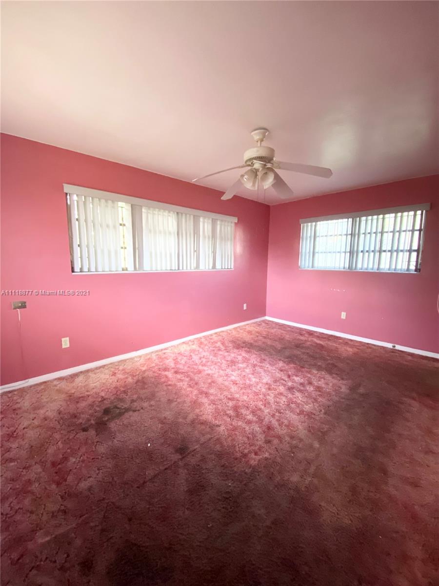270 Northwest 50th Street Miami, FL 33127 - Photo 11 of 21 an empty room with windows and ceiling fan