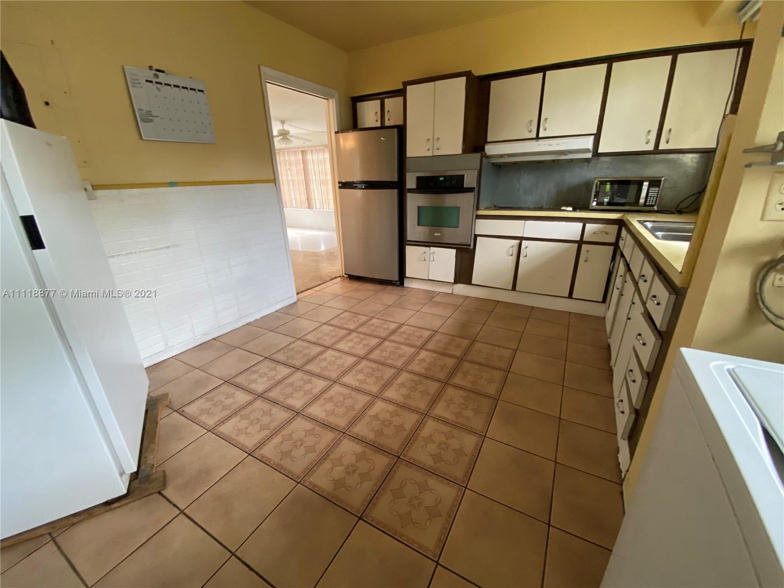 270 Northwest 50th Street Miami, FL 33127 - Photo 17 of 21 a bedroom with a bed and a refrigerator