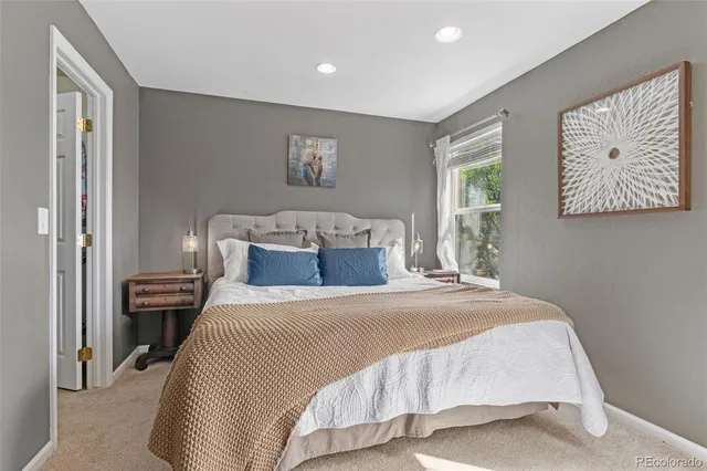 a bedroom with a bed and a painting on the wall