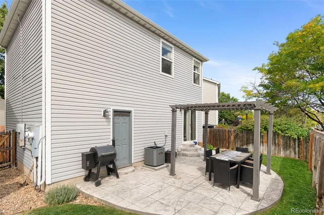 a view of a patio with table and chairs and a barbeque