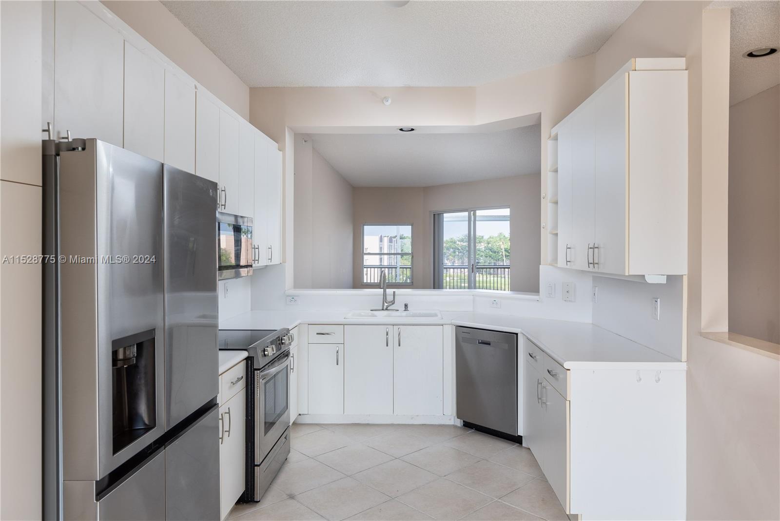 a large kitchen with stainless steel appliances lots of white cabinets