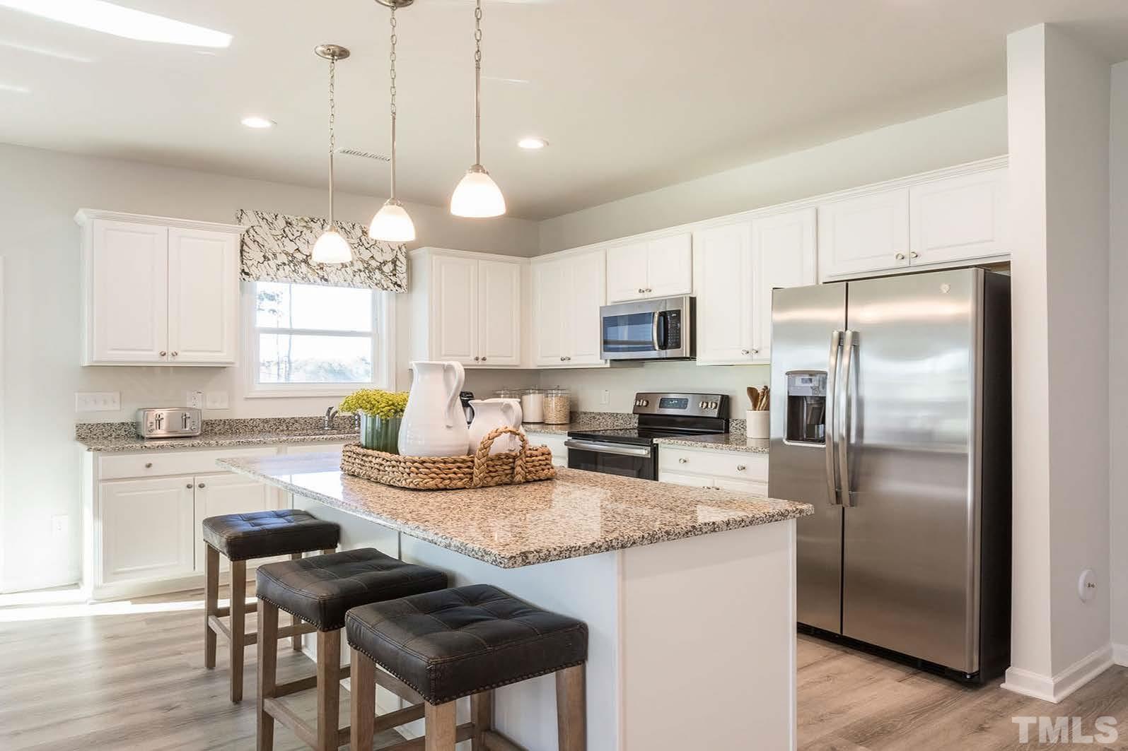 70 Roseshell Way Louisburg, NC 27549 - Photo 2 of 11 a kitchen with kitchen island granite countertop a sink a center island and cabinets