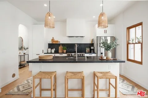 a kitchen with stainless steel appliances granite countertop a sink and a refrigerator