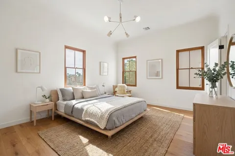a spacious bedroom with a bed and dresser