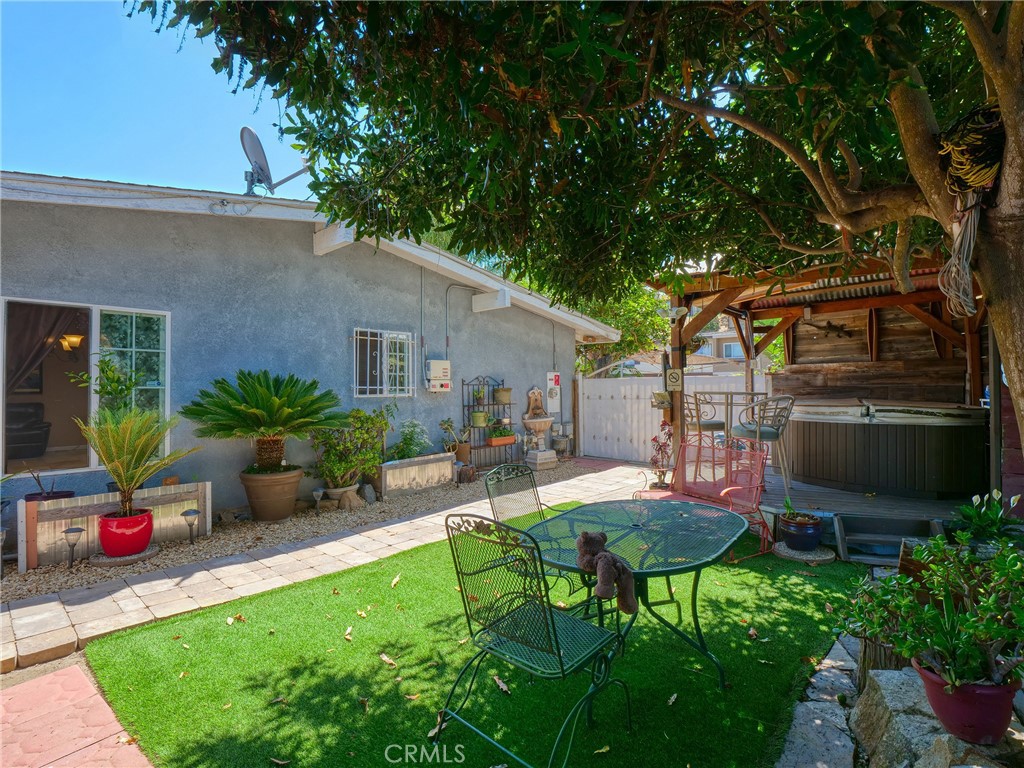 820 Raintree Place Vista, CA 92084 - Photo 26 of 29 a view of a backyard with table and chairs potted plants and a large tree