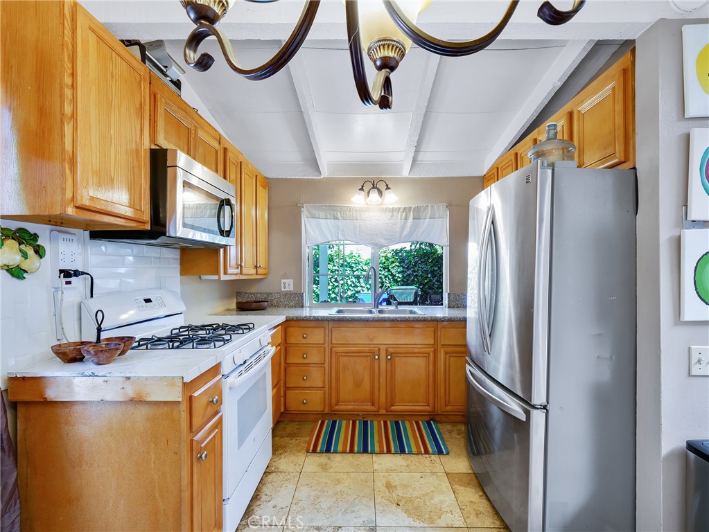820 Raintree Place Vista, CA 92084 - Photo 7 of 29 a kitchen with stainless steel appliances granite countertop a refrigerator a sink and a stove